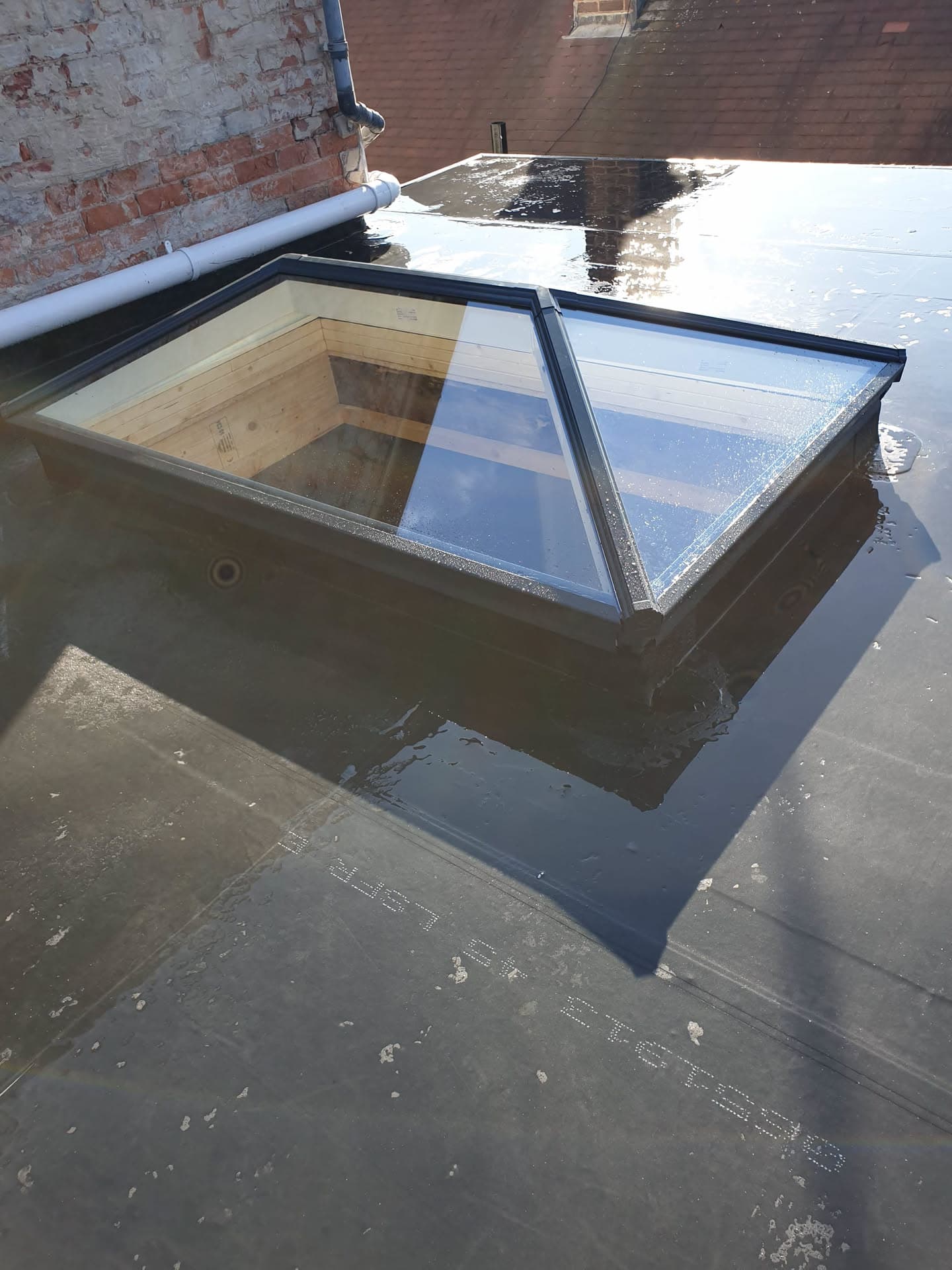 Flat roof with glass roof lantern and white guttering