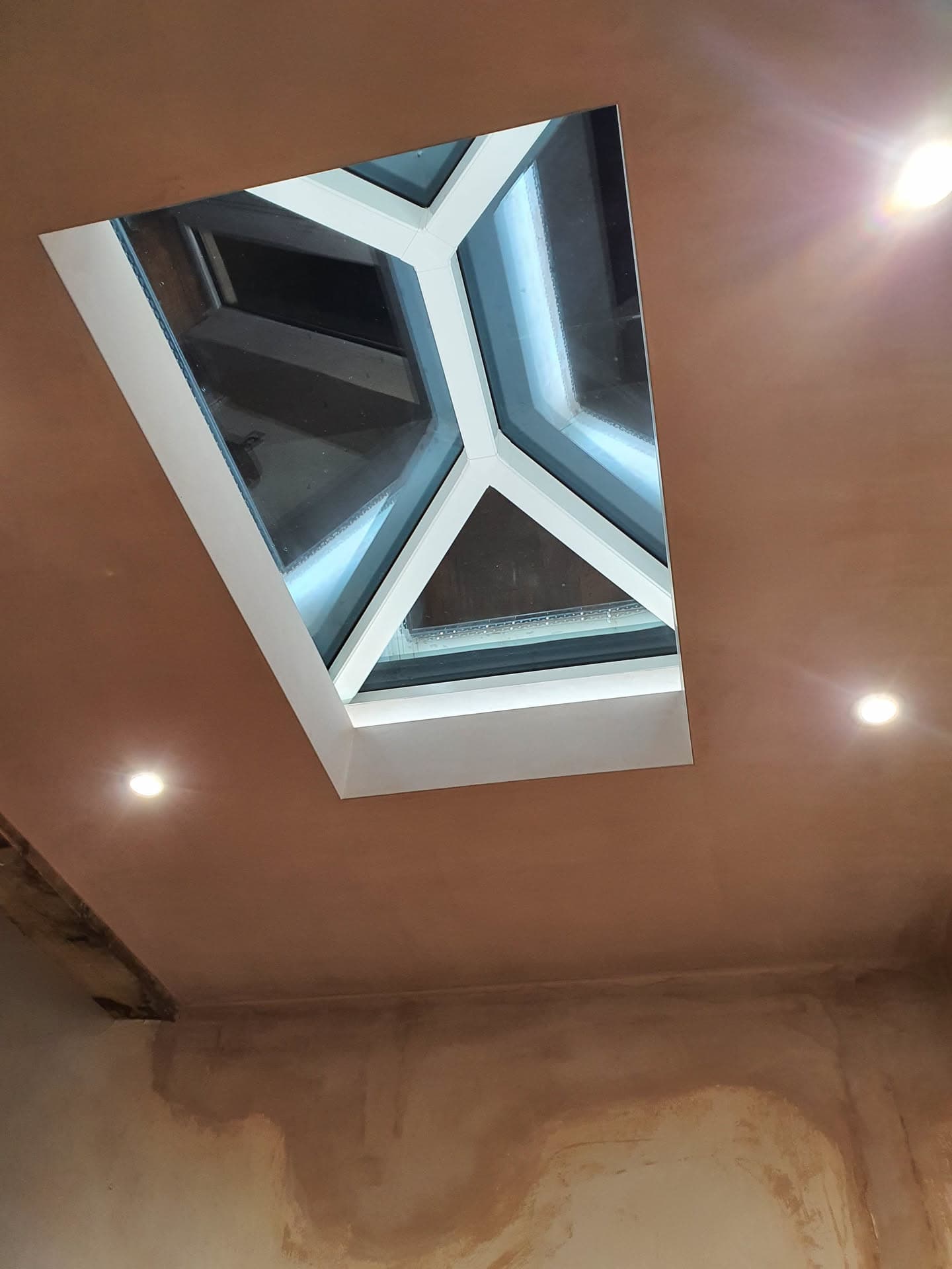 Lantern roof light with white frame and glazed panels viewed from inside