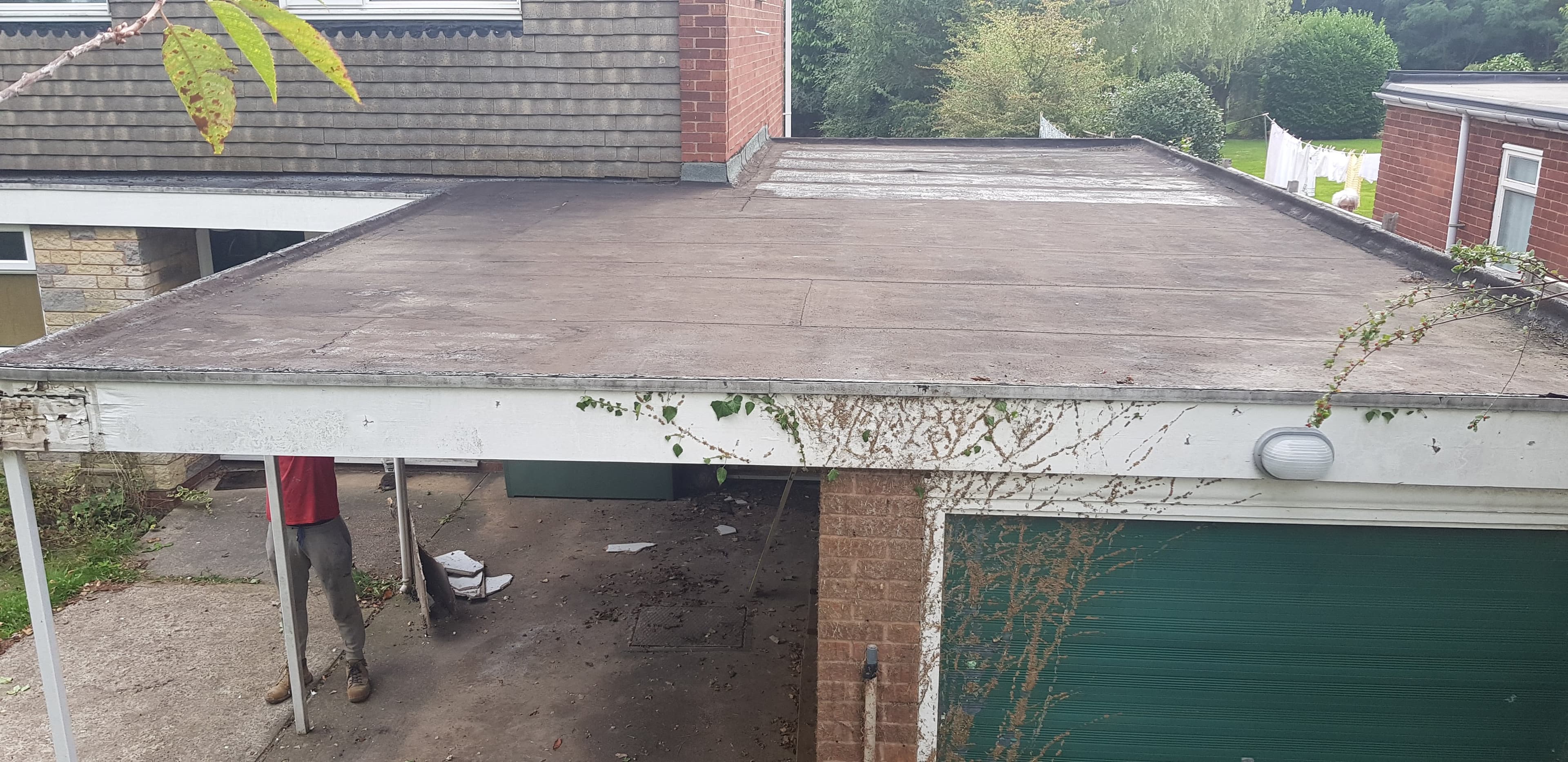 Flat roof with brown felt covering on residential garage extension