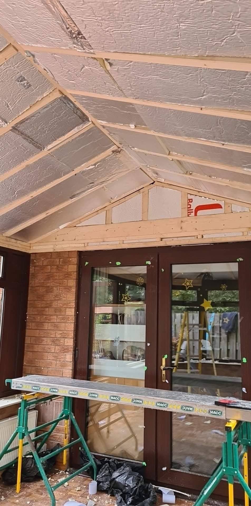 Interior view of conservatory roof with exposed timber frame and foil insulation between rafters