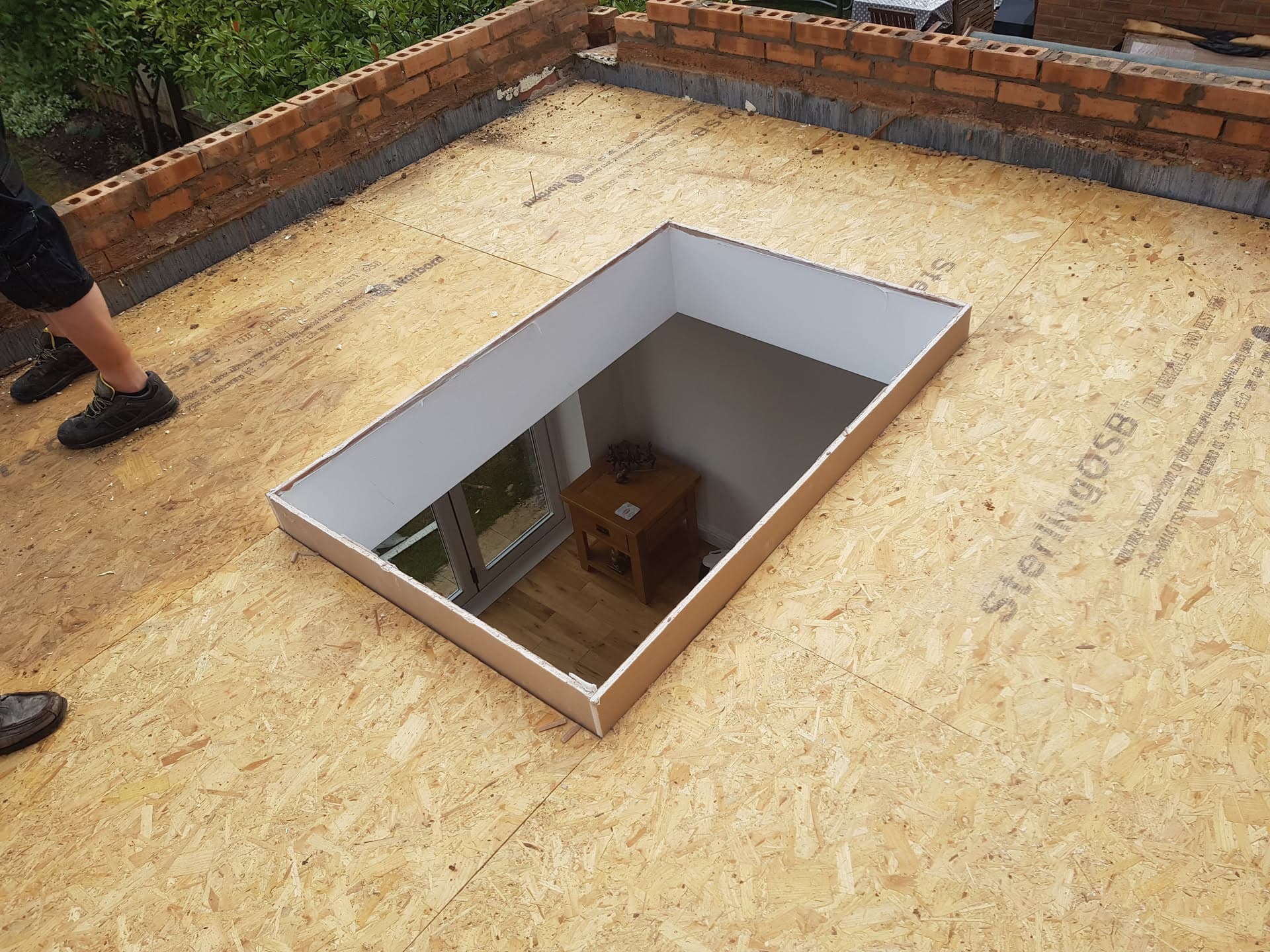 Flat roof installation with OSB decking and skylight opening during construction