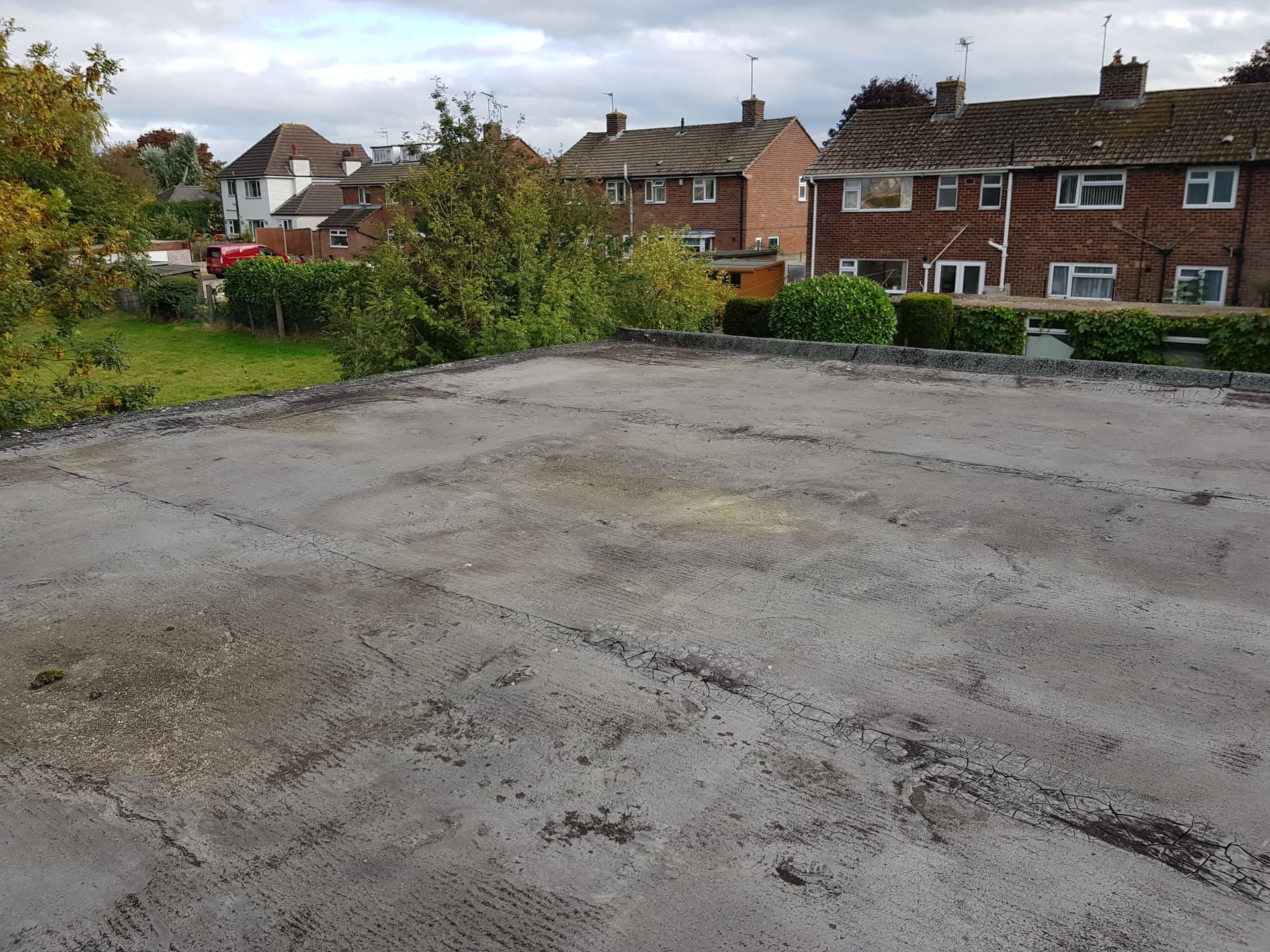 Weathered flat roof surface with felt covering showing wear and damage
