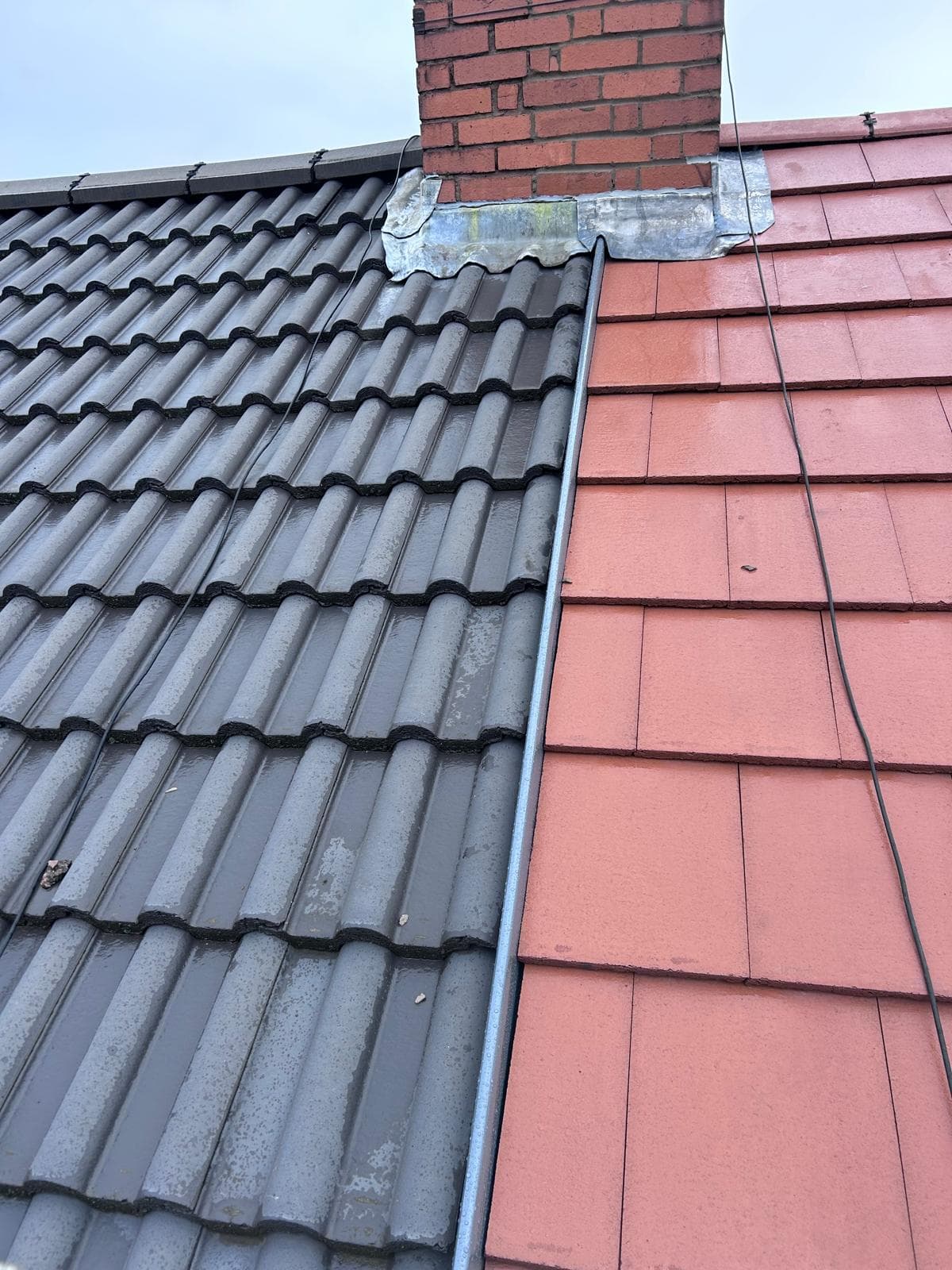 Concrete tile roof joined to plain clay tiles with chimney leadwork